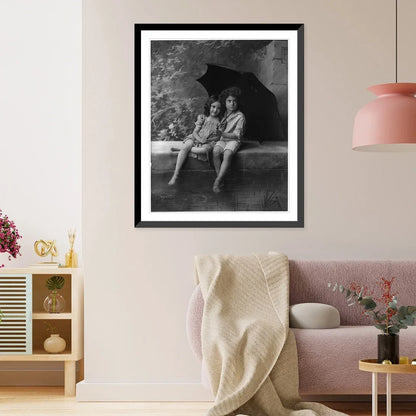 Historic Framed Print, [2 children on fountain wall, under umbrella in rain], 17-7/8" x 21-7/8"